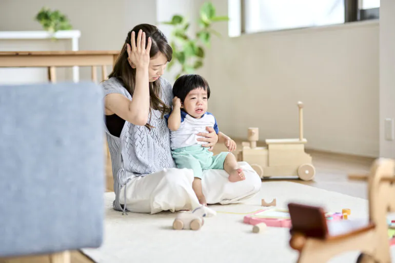 耳を触って泣く子供